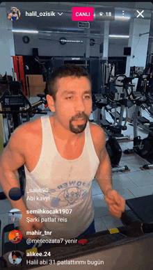 a man in a tank top is running on a treadmill in a gym with a canli button