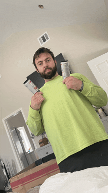 a man in a bright green shirt holds a can of soda