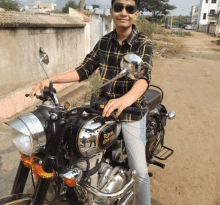 a man is standing next to a royal enfield motorcycle