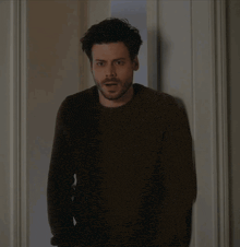 a man with a beard is peeking out of a doorway