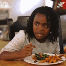 a young boy sitting at a table with a plate of food and a sign that says wife and swap