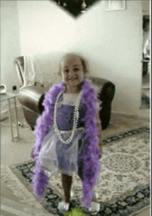 a little girl wearing a purple dress and a pearl necklace