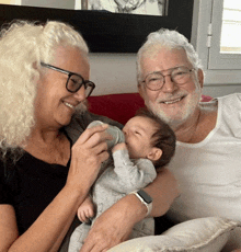 a woman is feeding a baby from a bottle and the baby is smiling