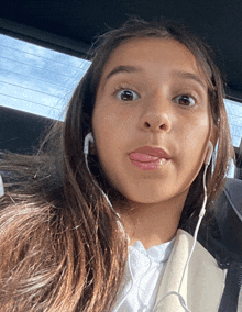 a young girl wearing headphones making a face