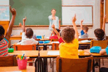 a group of children are raising their hands in a classroom to answer the question .