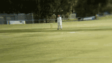 a man playing a game of cricket on a field with a sign in the background that says ' cricket '