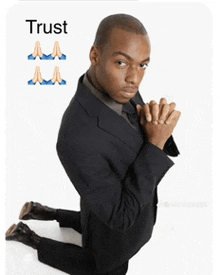 a man in a suit is kneeling down with his hands folded and the word trust written above him