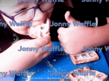 a boy is eating a waffle with the name jonny waffle written on it