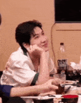a man is sitting at a table with a bowl of food and a bottle of pepsi .