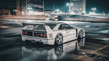 a white sports car is parked in a wet parking lot at night