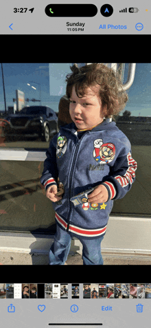 a phone screen shows a picture of a little boy in a mario jacket