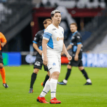 a soccer player wearing a white shirt with orange on the front