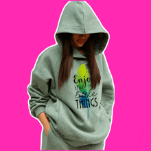 a girl wearing a grey hoodie that says enjoy the little things