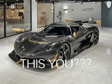 a black sports car is parked in a garage with the words `` this you ? '' written on it .