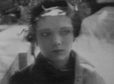 a black and white photo of a woman 's face with a crown on her head