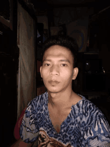 a young man wearing a blue shirt with a tiger print