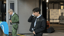 two men standing in front of a wall that says yokoh mall on it