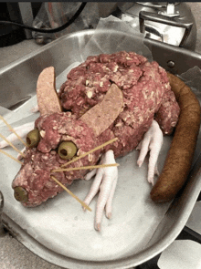 a rat made out of meat and chicken feet is on a pan