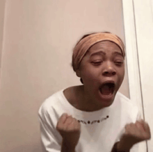 a woman is making a funny face with her mouth open and her hands in the air .