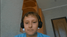 a boy wearing headphones looks at the camera