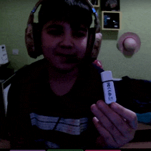 a boy wearing headphones is holding a usb stick that says ' rcc ' on the front