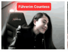 a woman is sitting in a gaming chair with a red sign that says führerim countess .