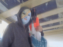 a person wearing a mask holds a nerf gun