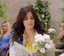 a woman holding a bouquet of white flowers and a book that says ' a little canvas ' on it