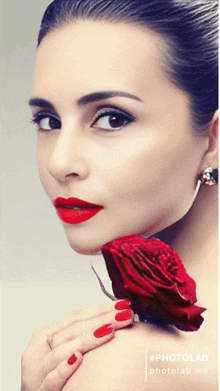 a woman with red lipstick and red nails is holding a rose