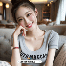 a woman wearing a grey shirt that says toto maccau on it