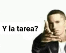 a man in a black jacket is making a hand gesture and says `` y la tarea ? ''