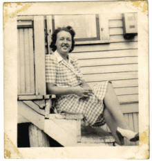 a woman in a plaid dress is sitting on a set of stairs