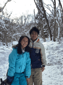 a boy and a girl pose for a photo in the snow