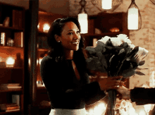 a woman is holding a bouquet of flowers in a vase .