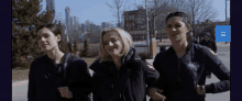 three female firefighters are posing for a picture and one of them is wearing a jacket that says chicago fire