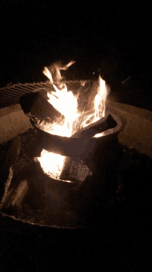 a fire is burning in a metal container in the dark