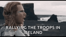 a man with long hair is standing in front of a rocky cliff and the words rallying the troops in iceland