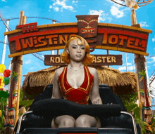 a woman rides a roller coaster in front of a sign that says the twisted totem