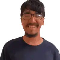 a man with glasses and a beard smiles for the camera