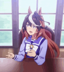 a girl in a sailor suit is sitting at a table with her hands outstretched