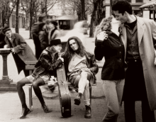 a black and white photo of a group of people including a man sitting on a bench