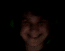 a blurry picture of a person 's face in the dark with a green light behind them .