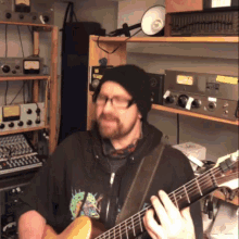 a man playing a guitar in front of a shelf with a sticker on it that says ' a ' on it