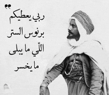 a black and white photo of a man with arabic writing on the bottom