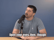 a man singing into a microphone with the words open your eyes then though