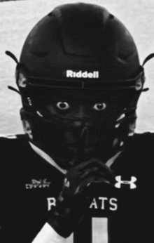 a black and white photo of a football player wearing a helmet that says riddell