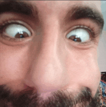 a close up of a man 's face with a beard making a funny face