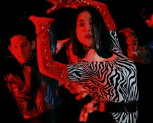 a woman in a zebra print dress and red gloves dancing