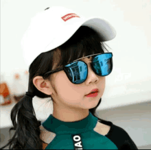 a little girl wearing sunglasses and a white baseball cap with the word supreme on it