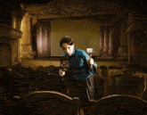 a woman in a blue shirt is holding a hammer in an empty theater